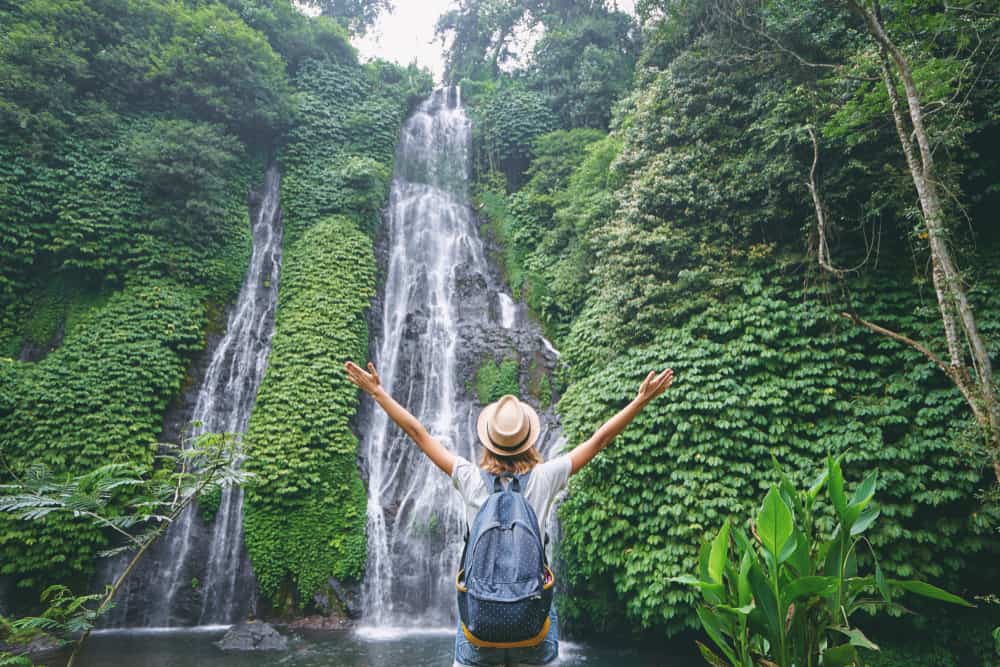 Person standing in front of Bali waterfalls